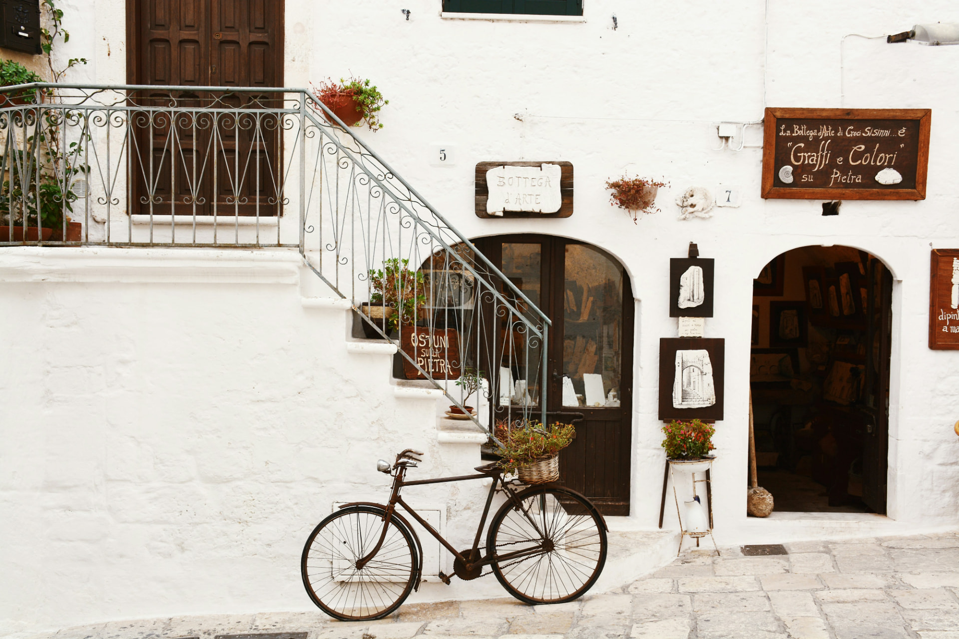 Bicycle by a whitewashed artisan shop in Ostuni